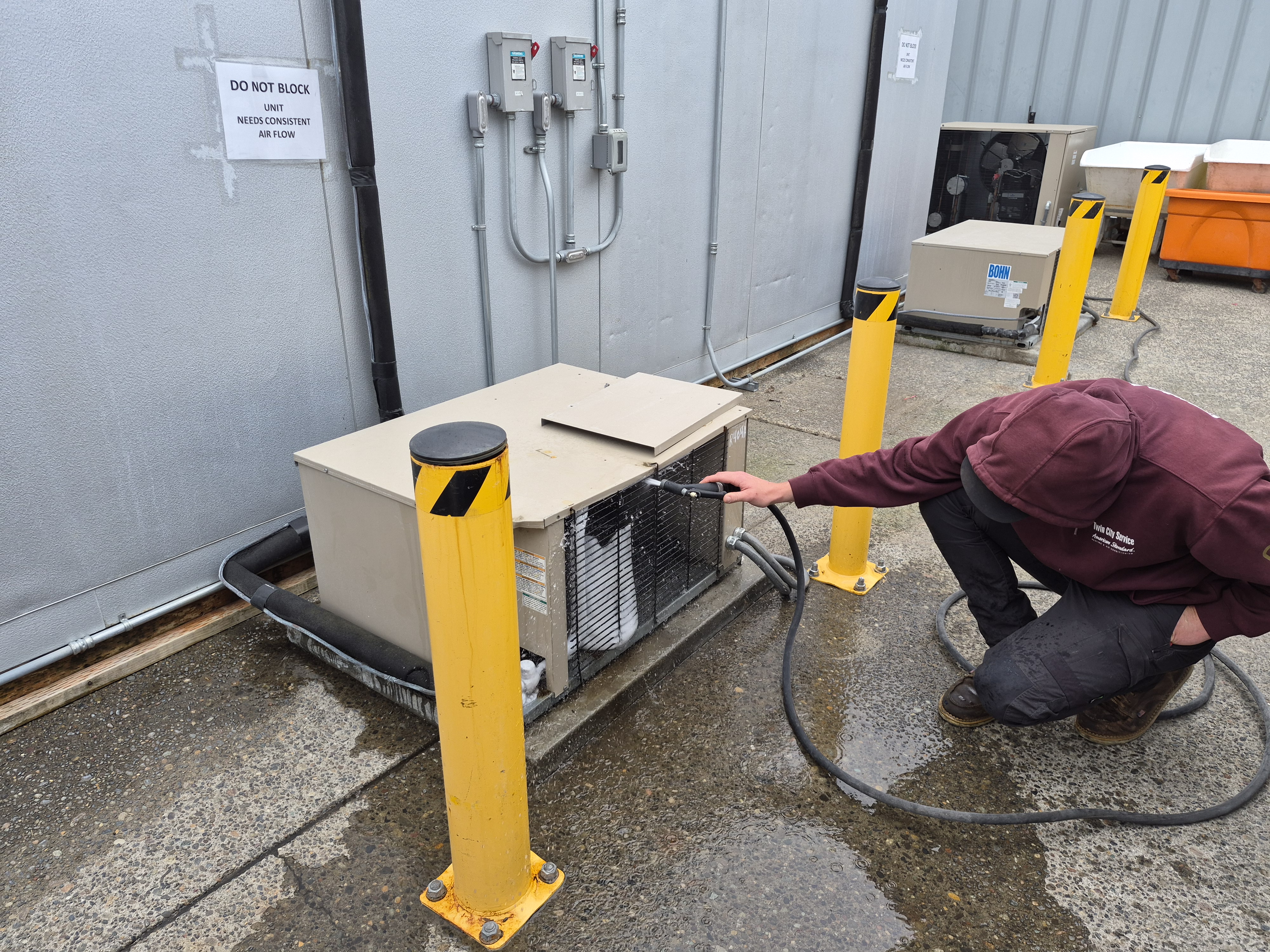 Twin City Service technician servicing an outdoor commercial refrigeration condensing unit